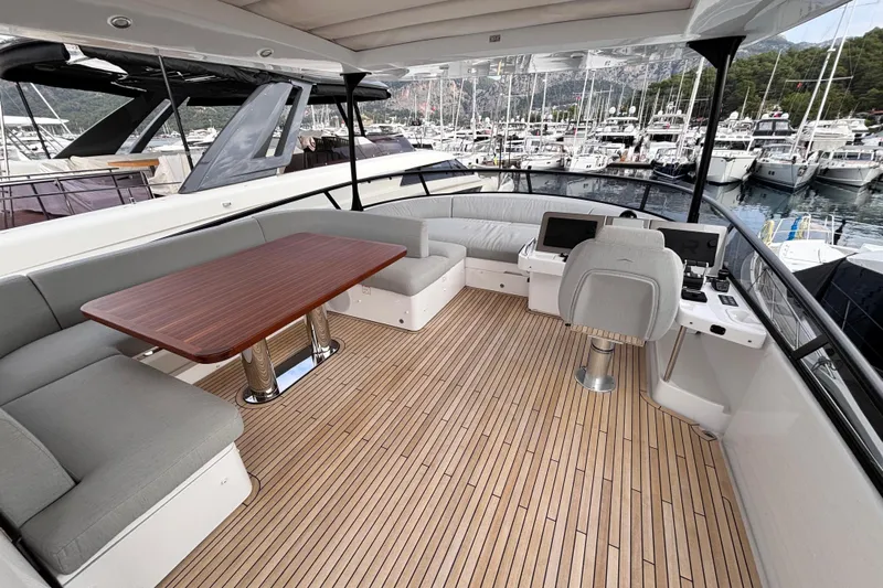 T&b Yacht Photos Pics Luxurious 2025 Azimut Magellano 66 yacht deck with seating and helm, docked in marina.