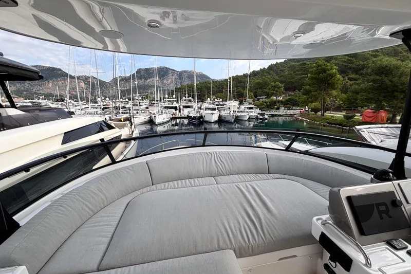 T&b Yacht Photos Pics Luxurious 2025 Azimut Magellano 66 yacht interior with marina view and surrounding mountains.