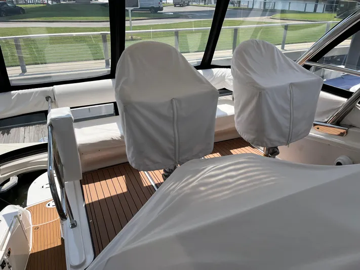 Greatest Escape Yacht Photos Pics 2006 Sea Ray 58 Sedan Bridge covered seats on deck, with wood flooring and large windows.