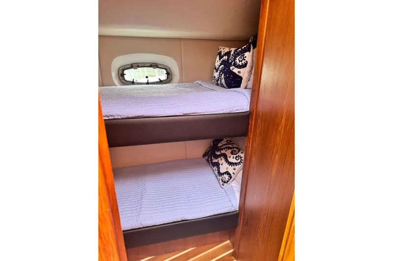  Yacht Photos Pics Bunk beds in 2014 Tiara Yachts 4300 Open, featuring cozy bedding and decorative pillows.