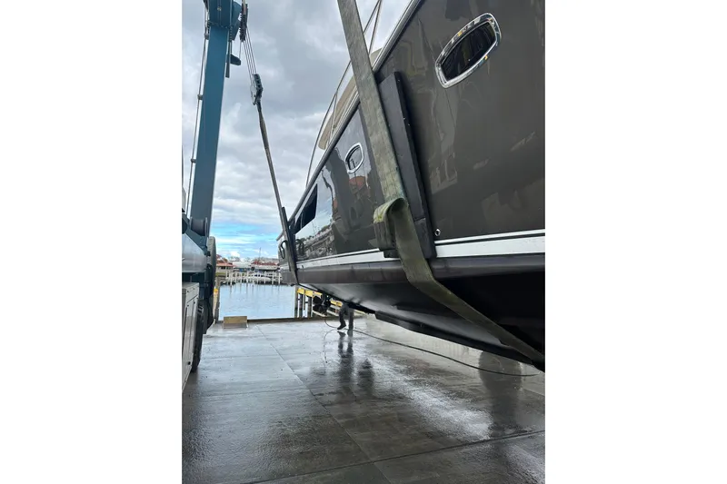  Yacht Photos Pics 2014 Tiara Yachts 4300 Open being lifted at a marina with overcast skies.