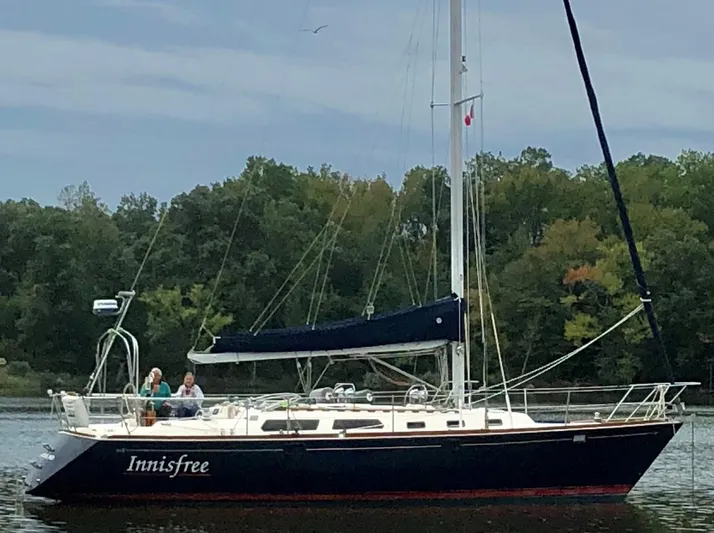 Innisfree Yacht Photos Pics Sailing yacht Sabre 425, 1994 model, named "Innisfree" on calm water with forest backdrop.