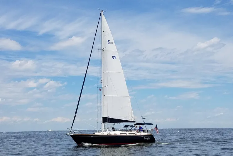 Innisfree Yacht Photos Pics Sailing yacht Sabre 425 from 1994 on open water under a blue sky.