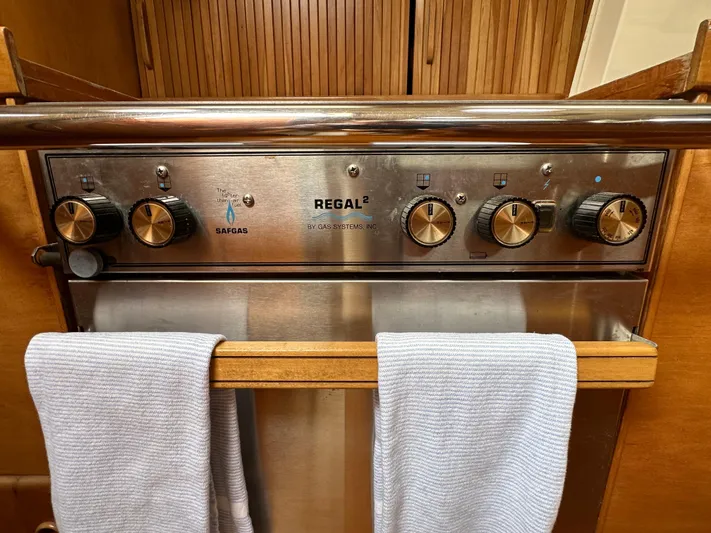 Innisfree Yacht Photos Pics Control panel of a 1994 Sabre SABRE 425 gas stove with towels hanging below.