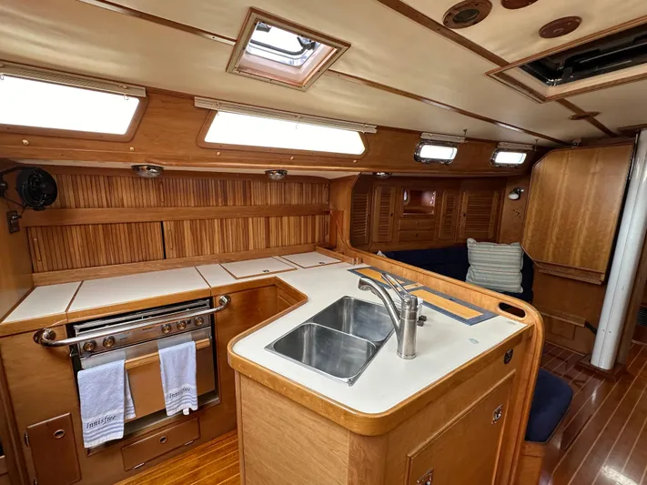 Innisfree Yacht Photos Pics 1994 Sabre SABRE 425 yacht interior with wooden cabinetry, kitchen sink, and oven.