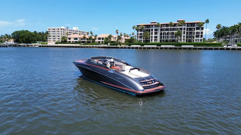 Lady D Yacht Photos Pics 2015 Riva Rivarama Super yacht cruising on a sunny waterfront with luxury buildings.