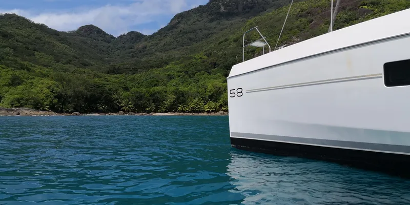 Between Yacht Photos Pics Leopard 58 yacht in scenic bay with lush green hills, 2018 model.