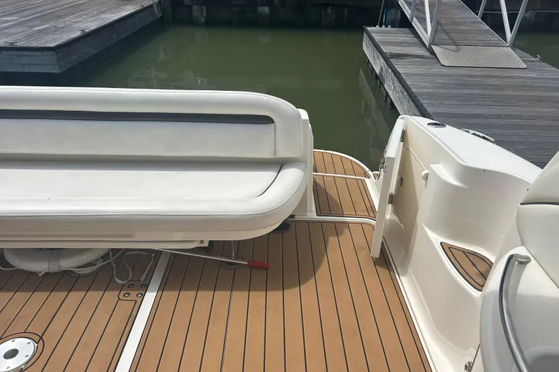 Whataboat Yacht Photos Pics 2005 Sea Ray 360 Sundancer boat deck with white seating and wooden flooring at a dock.