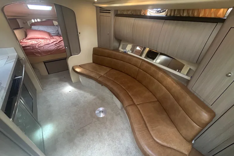 Whataboat Yacht Photos Pics 2005 Sea Ray 360 Sundancer interior with curved leather seating and cozy sleeping area.