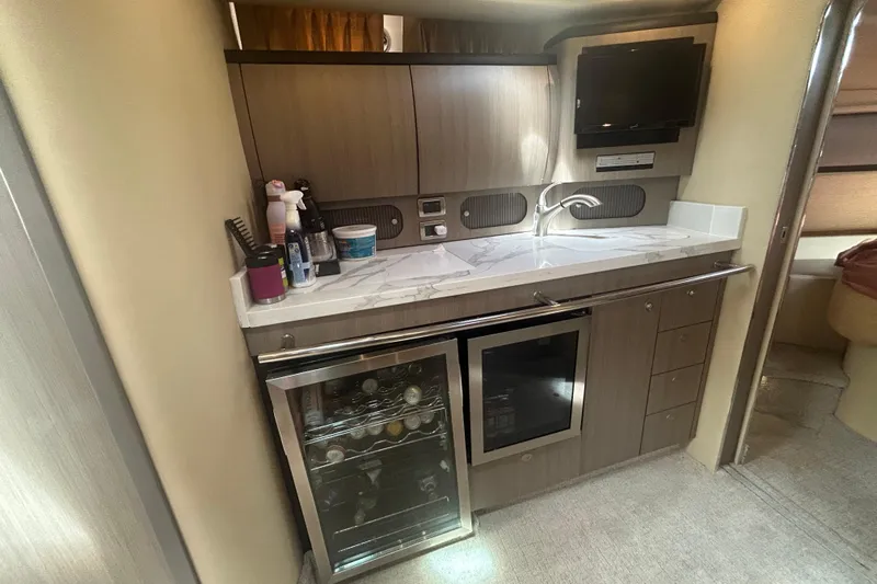 Whataboat Yacht Photos Pics 2005 Sea Ray 360 Sundancer galley with modern cabinetry, mini-fridge, and countertop appliances.