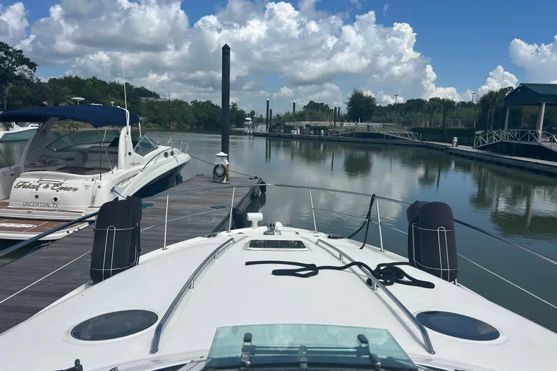 Whataboat Yacht Photos Pics 2005 Sea Ray 360 Sundancer docked at a serene marina under a partly cloudy sky.