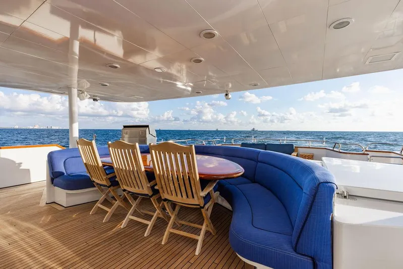 Empire Sea Yacht Photos Pics Luxury yacht deck with blue sofas and wooden table, ocean view.