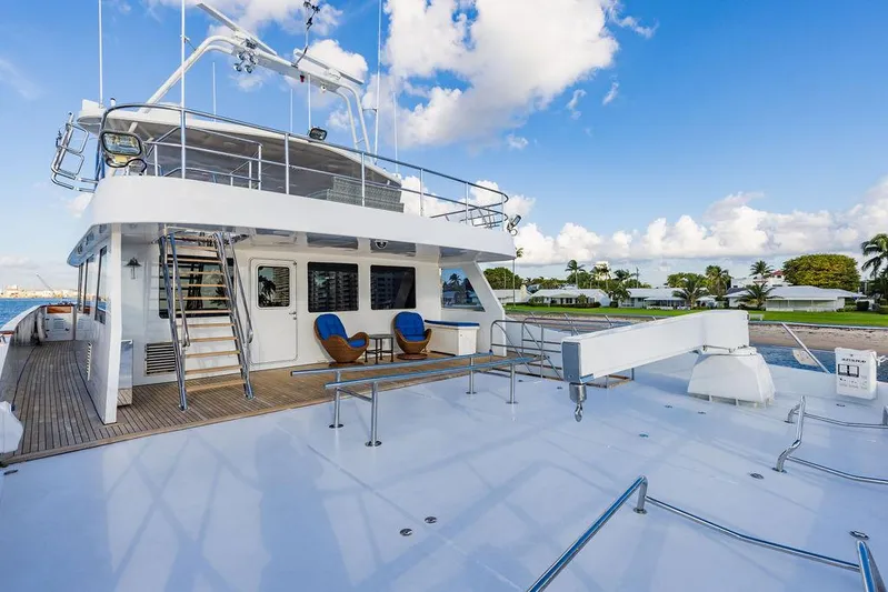 Empire Sea Yacht Photos Pics Luxury yacht deck with seating area, blue sky, and palm trees.