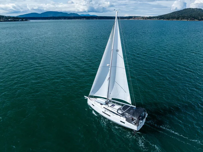Into The Blue Yacht Photos Pics 2022 Jeanneau Sun Odyssey 410 sailing on a serene, expansive blue sea.
