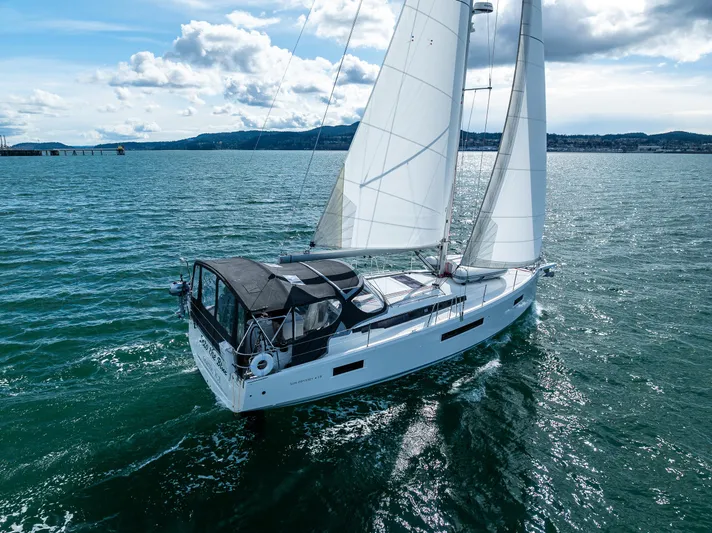 Into The Blue Yacht Photos Pics 2022 Jeanneau Sun Odyssey 410 sailing on open water under clear skies.