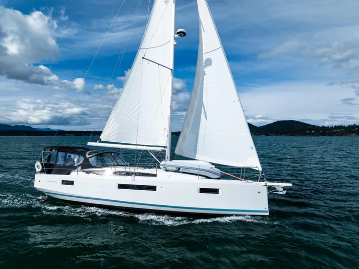 Into The Blue Yacht Photos Pics 2022 Jeanneau Sun Odyssey 410 sailing on open water under clear skies.