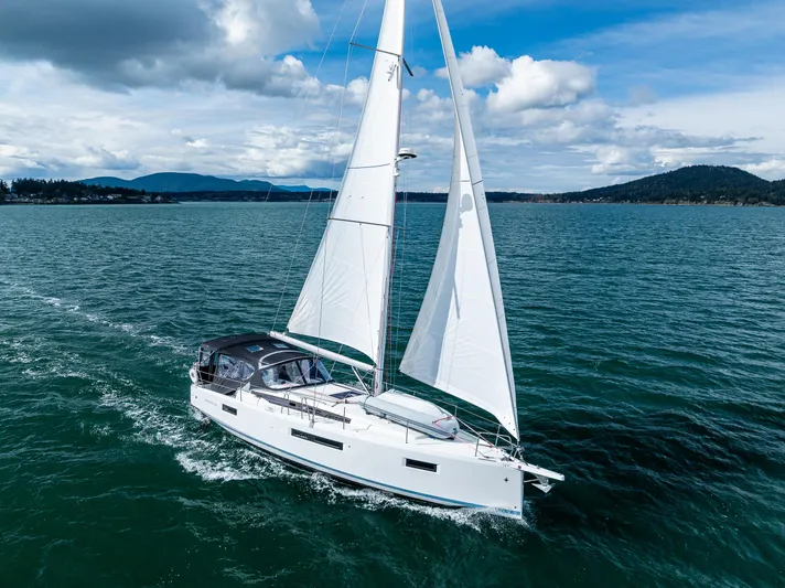 Into The Blue Yacht Photos Pics 2022 Jeanneau Sun Odyssey 410 sailing on open water under a clear sky.