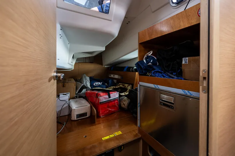 Into The Blue Yacht Photos Pics Interior storage area of 2022 Jeanneau Sun Odyssey 410 sailboat, featuring shelves and equipment.