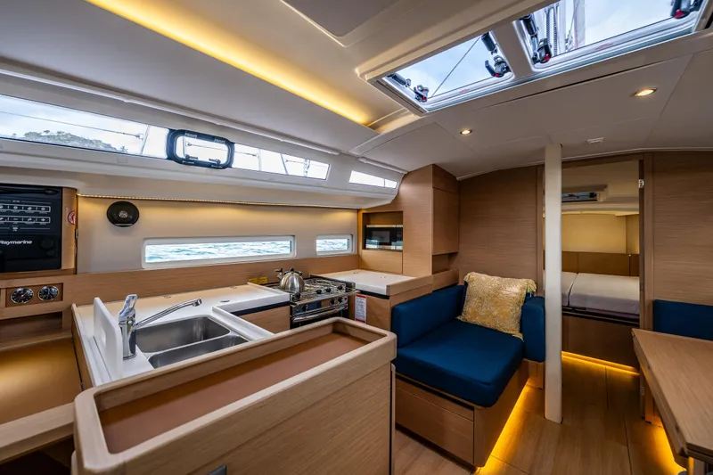Into The Blue Yacht Photos Pics Interior of 2022 Jeanneau Sun Odyssey 410 yacht, featuring modern kitchen and cozy seating area.