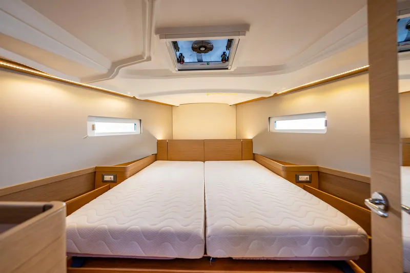 Into The Blue Yacht Photos Pics 2022 Jeanneau Sun Odyssey 410 cabin interior with twin beds and modern design.