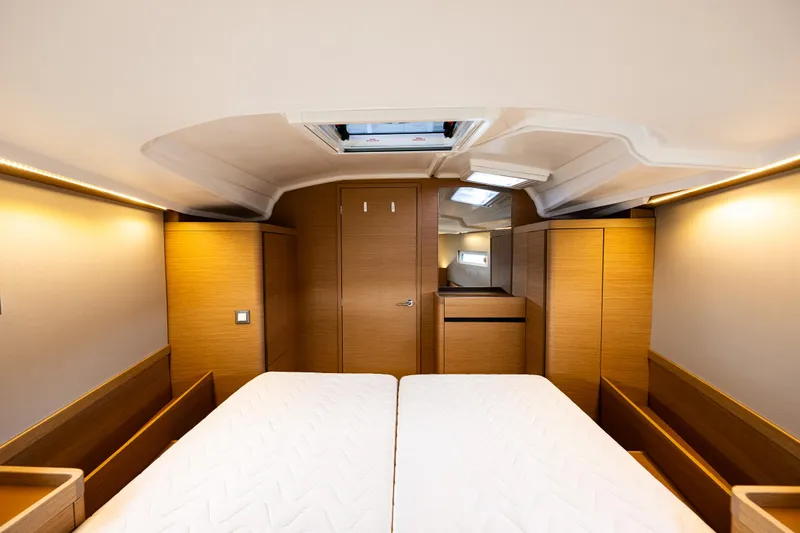 Into The Blue Yacht Photos Pics Interior cabin of 2022 Jeanneau Sun Odyssey 410 yacht, featuring twin beds and wooden finish.