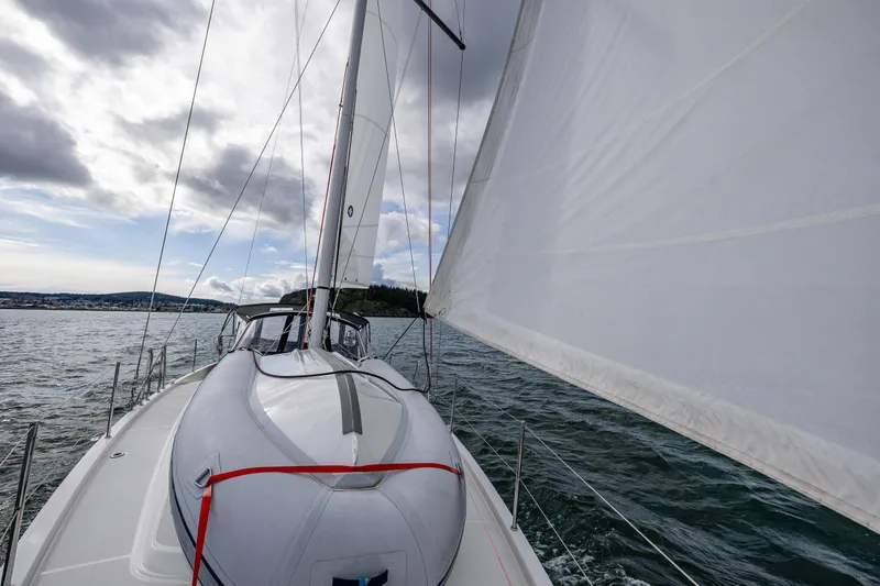 Into The Blue Yacht Photos Pics 2022 Jeanneau Sun Odyssey 410 sailing on open water under cloudy skies.