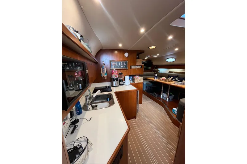 Summah Sled Yacht Photos Pics 1999 Tiara Yachts 4000 Express interior with kitchen and dining area, featuring wood finishes.