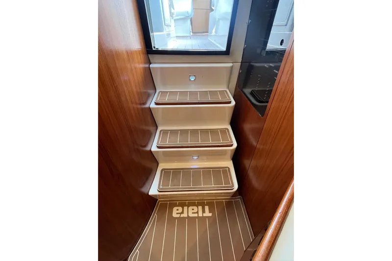 Summah Sled Yacht Photos Pics Staircase inside 1999 Tiara Yachts 4000 Express with wooden accents and branded mat.
