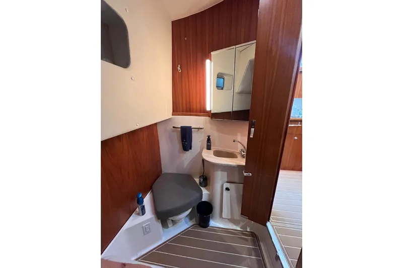 Summah Sled Yacht Photos Pics Bathroom interior of 1999 Tiara Yachts 4000 Express with wood paneling and compact fixtures.