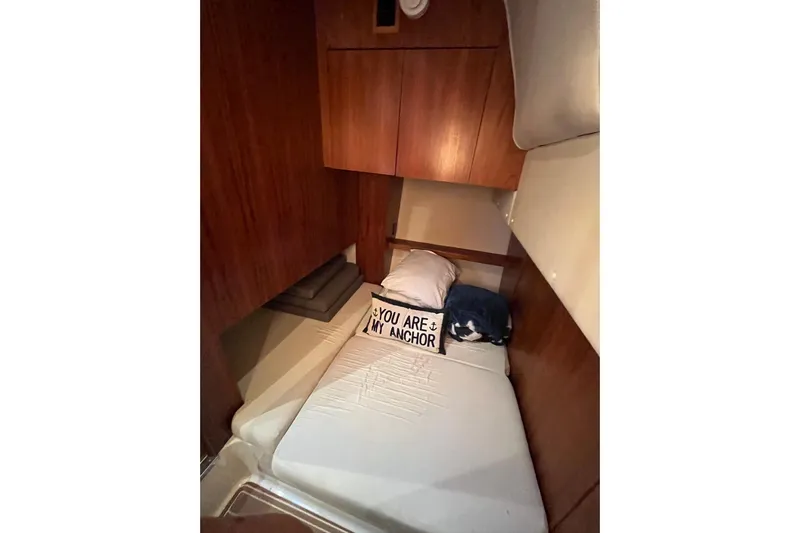 Summah Sled Yacht Photos Pics 1999 Tiara Yachts 4000 Express cabin with cozy bed and nautical-themed pillow.