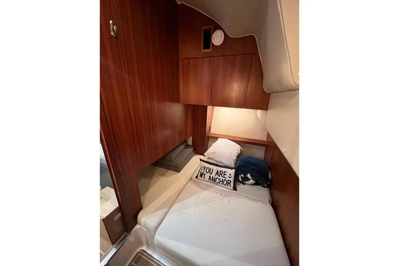 Summah Sled Yacht Photos Pics 1999 Tiara Yachts 4000 Express cabin with cozy bed and nautical decor.