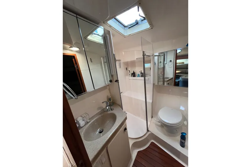Summah Sled Yacht Photos Pics Bathroom interior of 1999 Tiara Yachts 4000 Express, featuring sink, toilet, and shower.