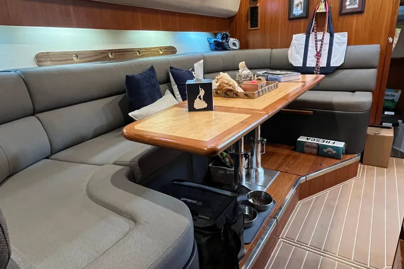Summah Sled Yacht Photos Pics 1999 Tiara Yachts 4000 Express interior with cozy seating and wooden table.