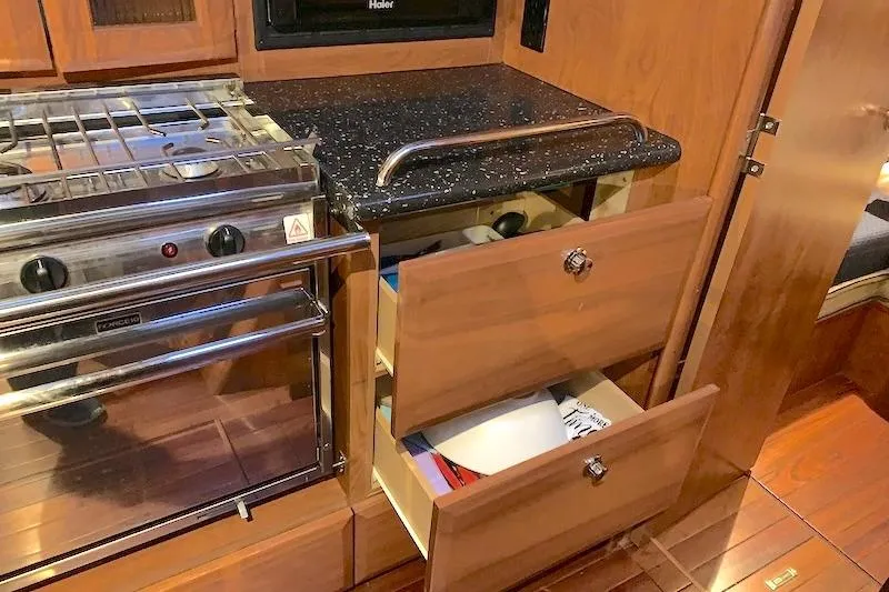 Sweet & Salty Yacht Photos Pics 2011 Hunter 39 yacht kitchen with stove, open drawers, and wooden cabinetry.