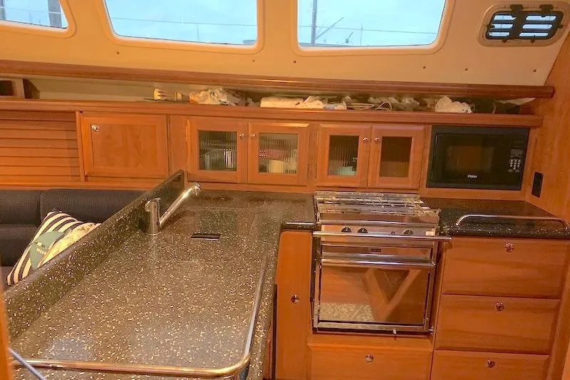 Sweet & Salty Yacht Photos Pics Interior of 2011 Hunter 39 yacht kitchen with wooden cabinets and modern appliances.