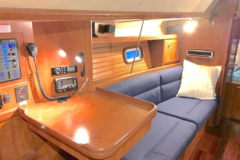 Sweet & Salty Yacht Photos Pics 2011 Hunter 39 yacht interior with navigation station and blue cushioned seating.