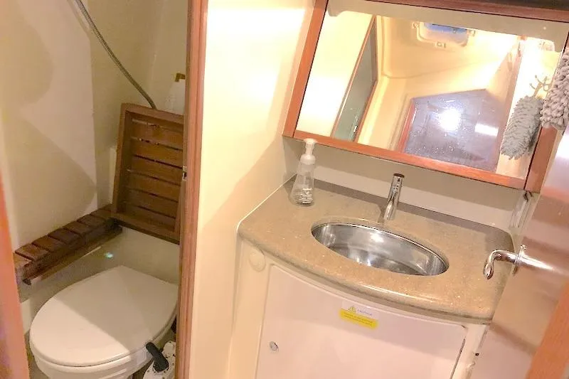 Sweet & Salty Yacht Photos Pics Compact bathroom in a 2011 Hunter 39 yacht with sink, mirror, and toilet.