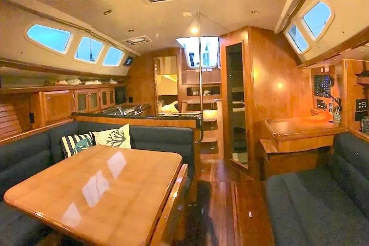 Sweet & Salty Yacht Photos Pics Interior of a 2011 Hunter 39 sailboat with wooden furnishings and cozy seating.