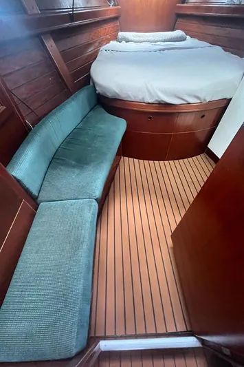 Chivalry Yacht Photos Pics Interior of 2000 Beneteau 461 yacht with wooden flooring, bed, and cushioned seating.