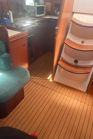 Chivalry Yacht Photos Pics Interior of 2000 Beneteau 461 sailboat with wooden flooring and compact kitchen area.