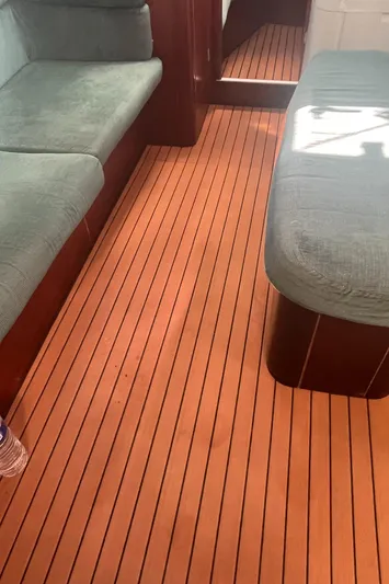 Chivalry Yacht Photos Pics Interior of 2000 Beneteau 461 sailboat with wooden flooring and cushioned seating.