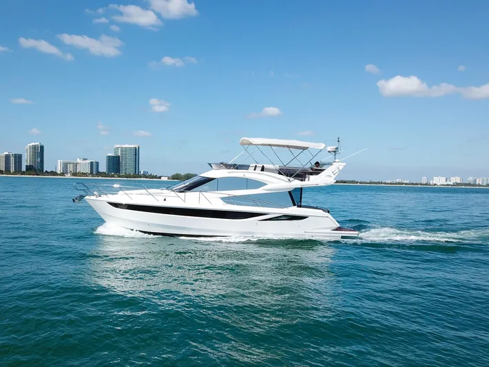  Yacht Photos Pics 2016 Galeon 420 Fly yacht cruising on blue water near city skyline.