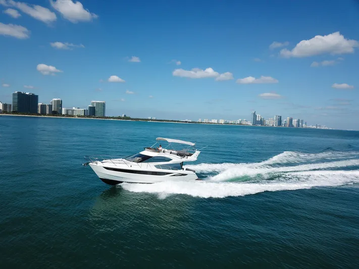  Yacht Photos Pics Galeon 420 Fly 2016 yacht cruising on blue ocean near city skyline.