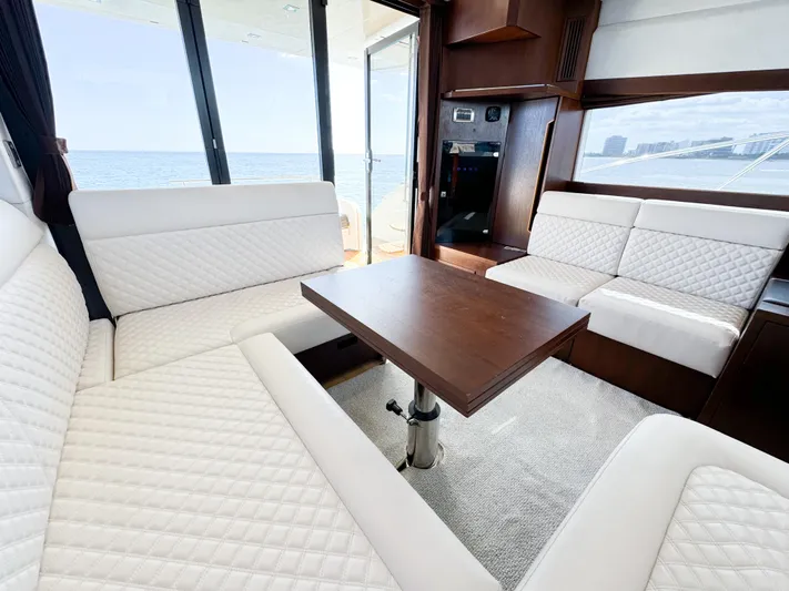  Yacht Photos Pics Luxurious interior of 2016 Galeon 420 Fly yacht with white seating and wooden table.