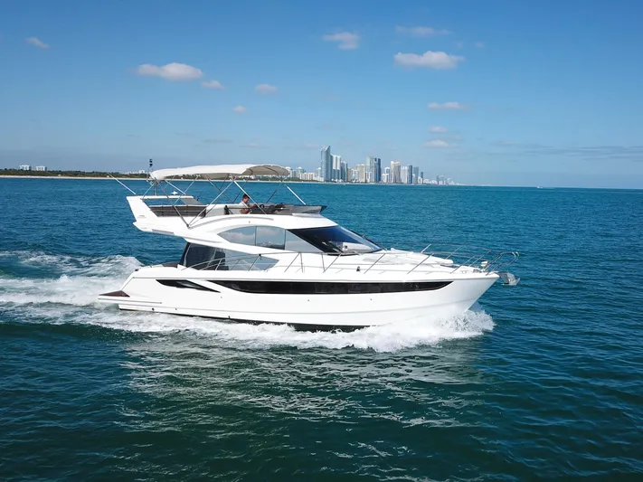 Yacht Photos Pics Galeon 420 Fly 2016 yacht cruising on blue ocean near city skyline.