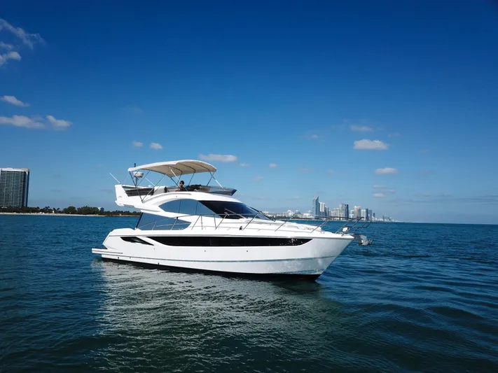  Yacht Photos Pics 2016 Galeon 420 Fly yacht cruising on open water with city skyline.