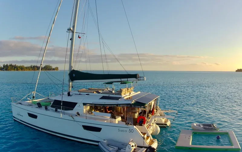 Jajapami Yacht Photos Pics 2017 Fountaine Pajot SABA 50 catamaran sailing on serene blue waters at sunset.