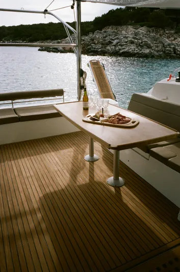 Yacht Photos Pics 2019 Lagoon 50 yacht deck with dining table, wine, and charcuterie, overlooking serene waters.