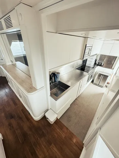 Laziza Yacht Photos Pics Modern kitchen interior on 2004 Benetti Sail Division 82 RPH yacht, featuring sleek white cabinetry.