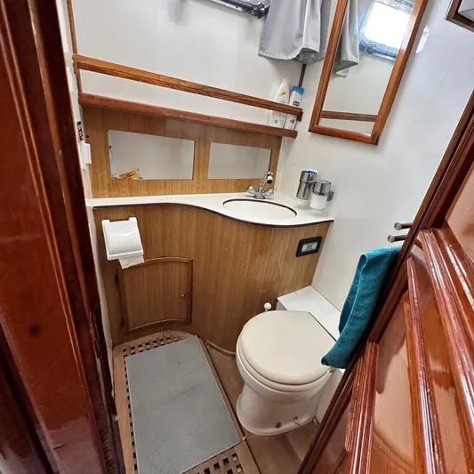  Yacht Photos Pics Compact bathroom in 1994 Viking Marin Caicco yacht with wooden accents and modern amenities.